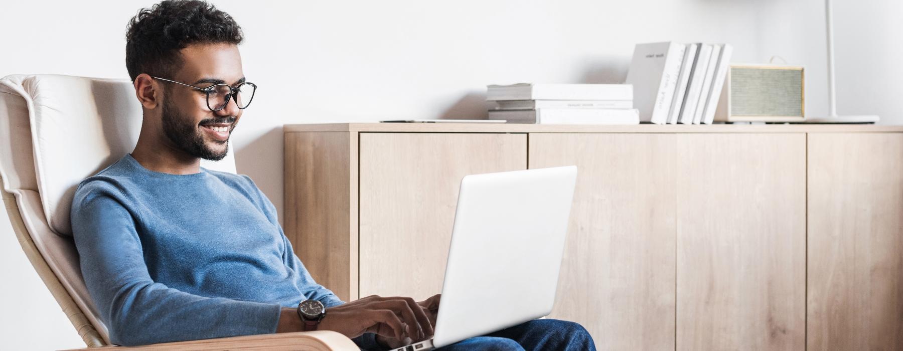 a man sitting in a chair with a laptop